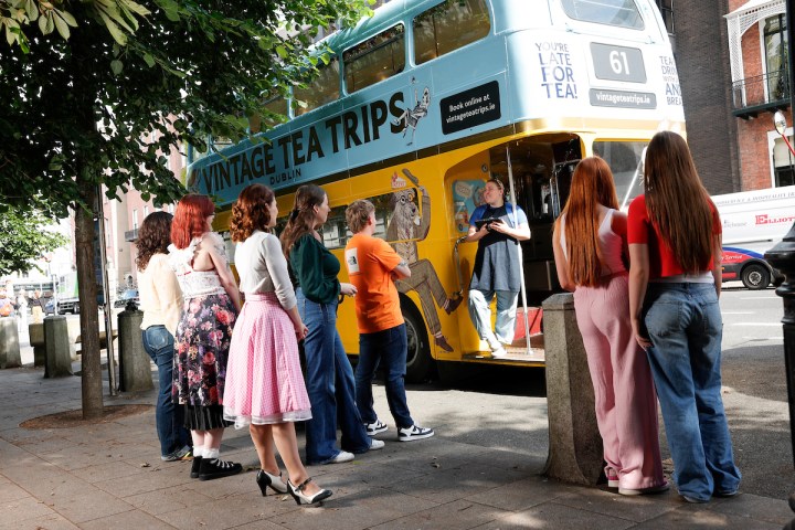 a group of people standing in front of a bus