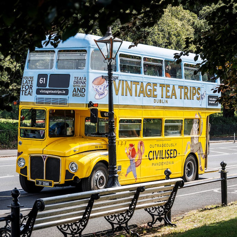 Vintage Tea Trips bus parked up next to ornate benches