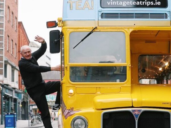 a person in a yellow bus driving down a street
