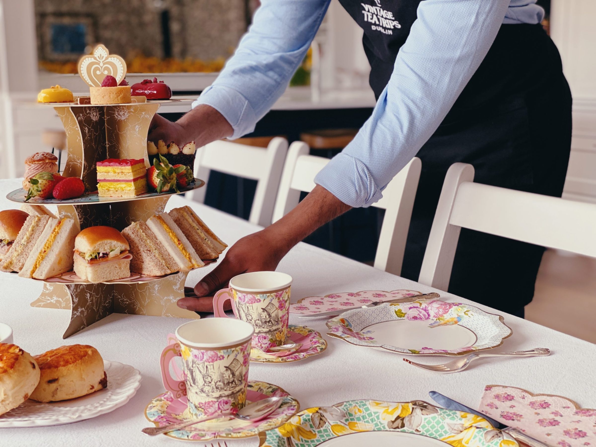 a person setting the table with afternoon tea