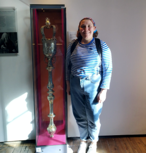 a woman standing in front of a statue of a man