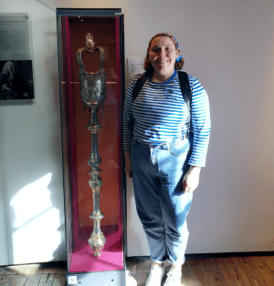 a woman standing in front of a statue of a man