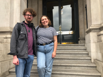 a man and a woman standing in front of a building