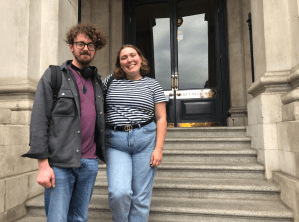 a man and a woman standing in front of a building