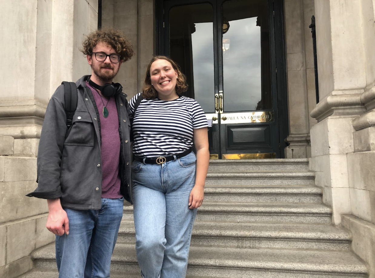 Screenshot 2022-08-29 at 15.21.11 a man and a woman standing in front of a building