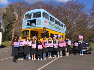 a group of people standing in front of a bus