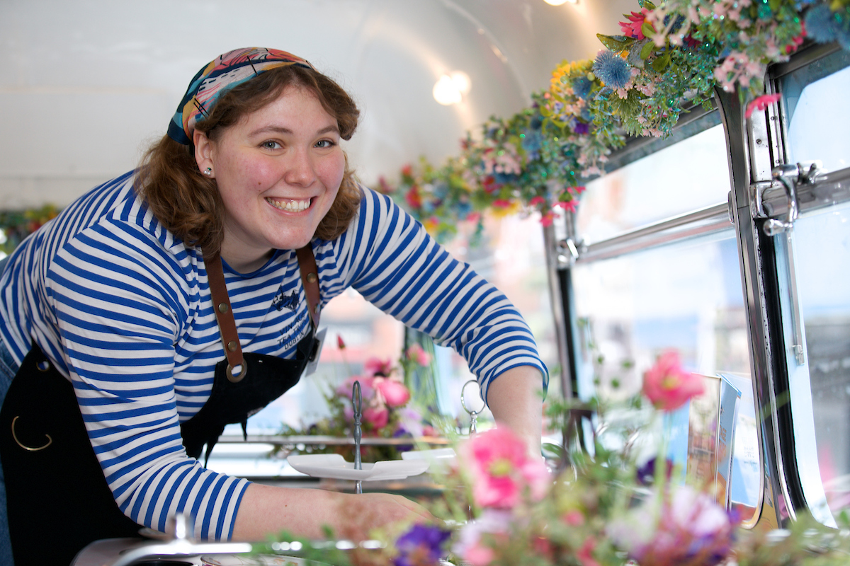 a person setting up a table on the upper deck of a bus