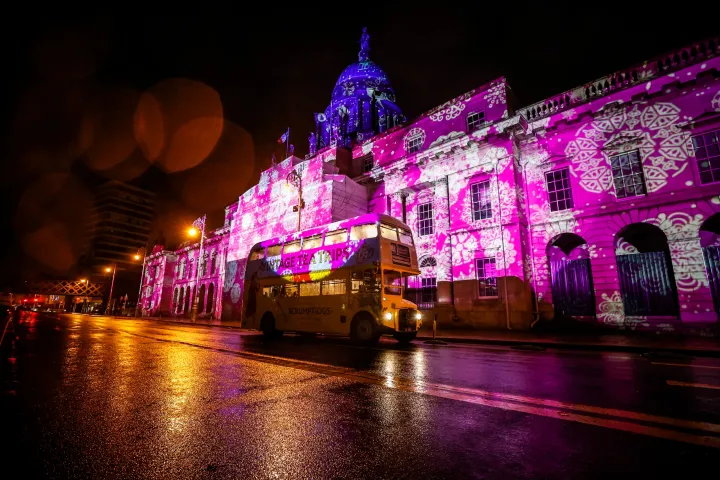 a colorful bus is lit up at night