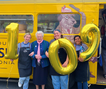 a group of people standing in front of a school bus