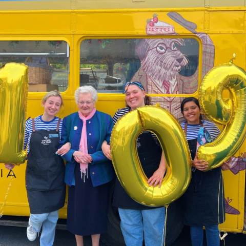 a group of people standing in front of a school bus