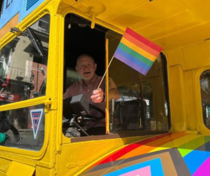 a passenger bus that is next to a colorful kite