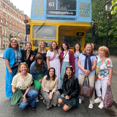 a hen party of people standing in front of a bus