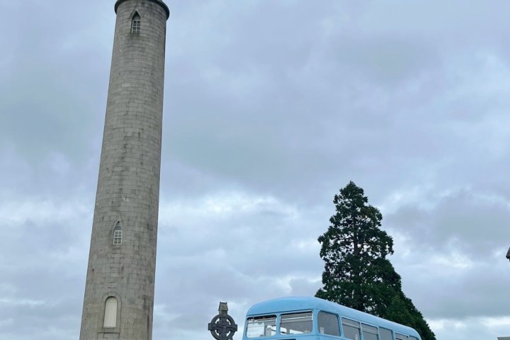 Vintage Tea Trips Bus parked next to Round Tower