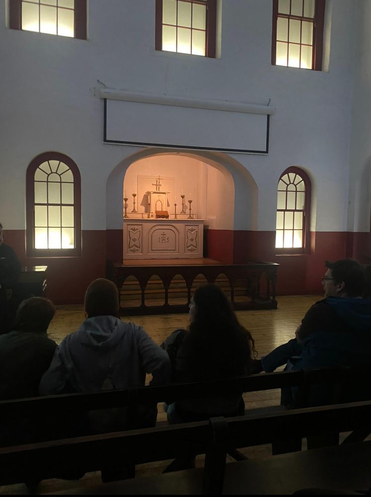 a group of people sitting in the chapel in Kilmainham Jail
