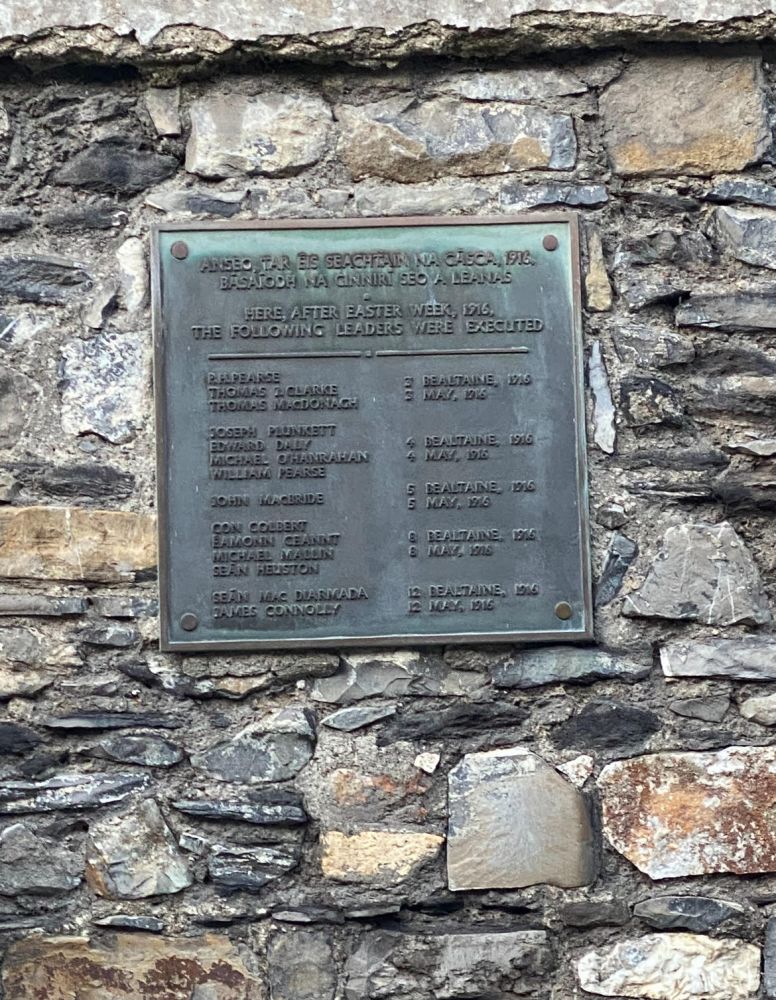 a stone wall with a memorial plaque on a brick wall