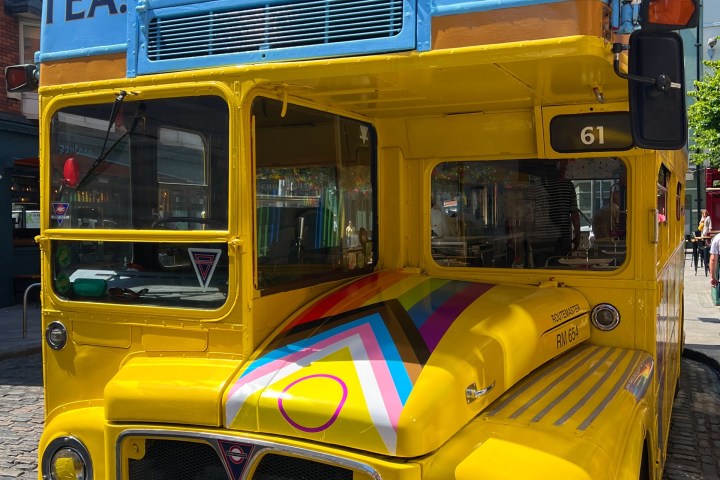 Front of Vintage Tea Trips Bus with a Pride flag on the bonnet