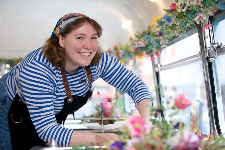 a woman standing in front of a cake