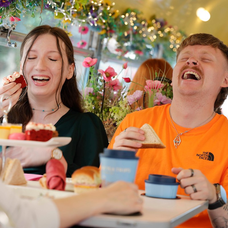 Bus passengers eating afternoon tea and laughing together