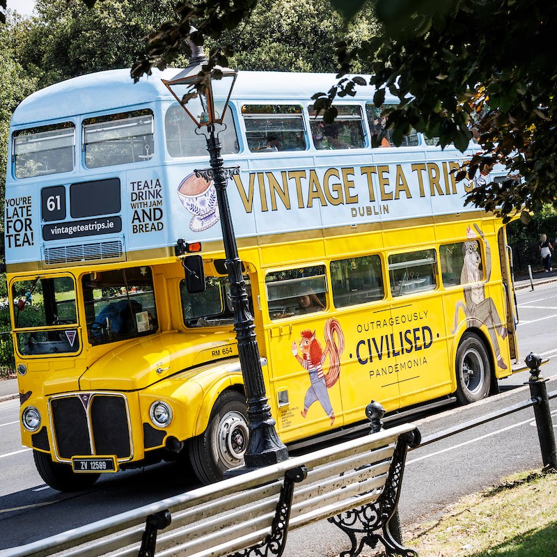 Vintage Tea Trips bus parked up next to ornate benches