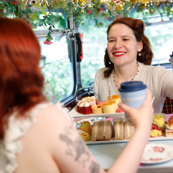 a woman sitting at a table with food and drinks