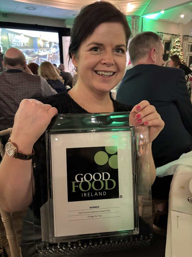 Smiling woman holds Good Food Ireland award at an event.