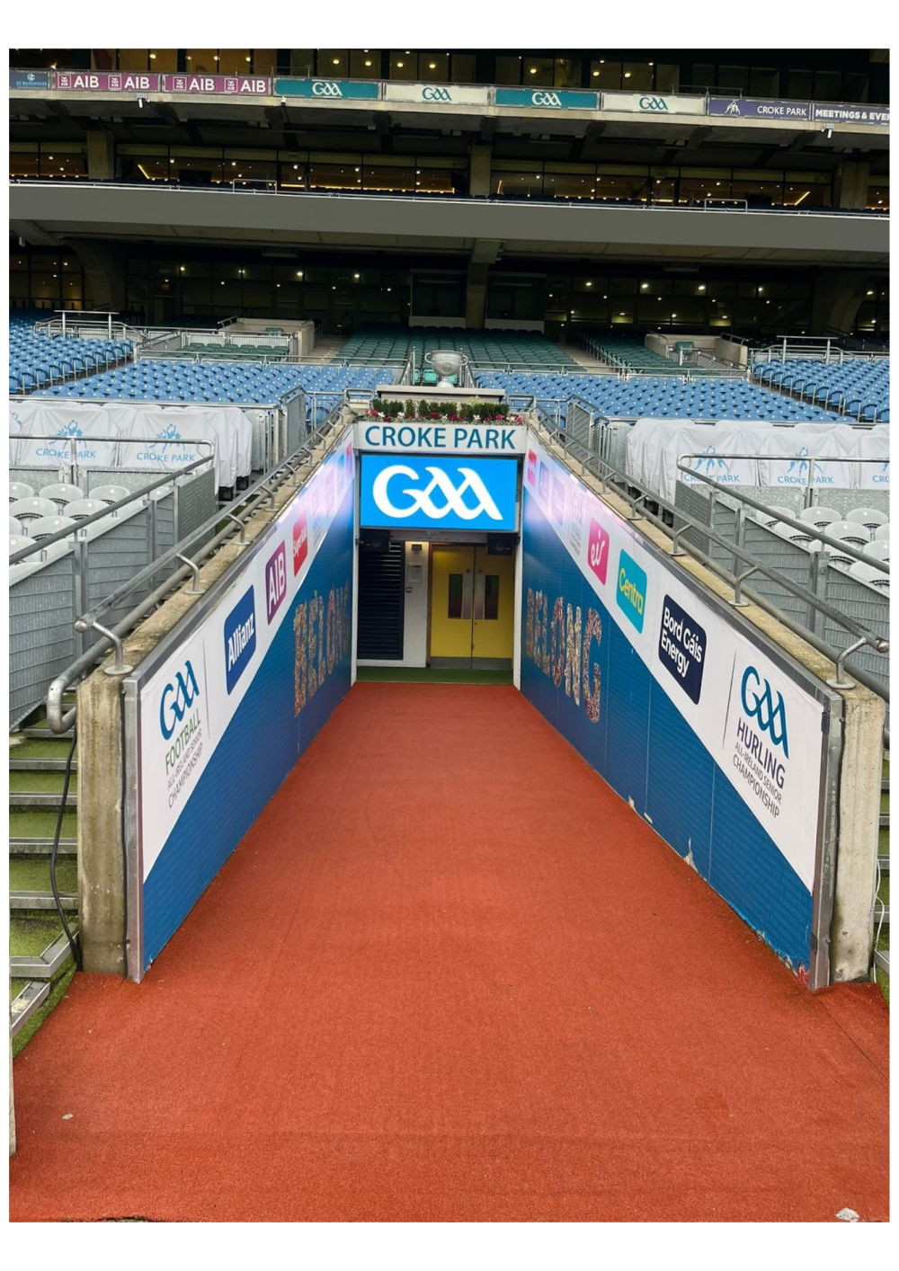 Stadium tunnel lined with advertisements and a red carpet leading to Croke Park entrance.