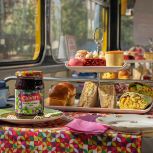 jar of jam on a table with afternoon tea plated behind