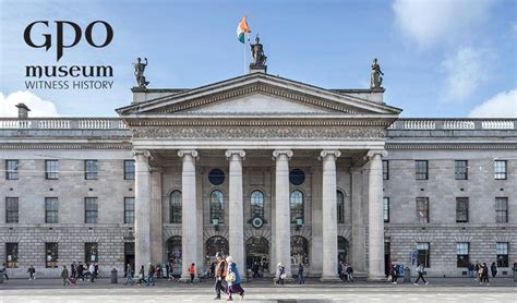 Front view of GPO Museum building with columns and Irish flag on top.