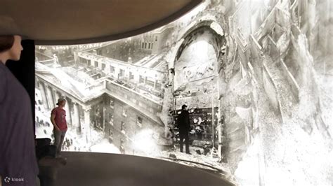 People viewing a large, panoramic historical photograph on a curved wall.