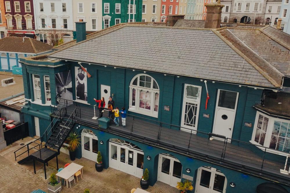 Aerial view of people standing on a blue building's balcony.