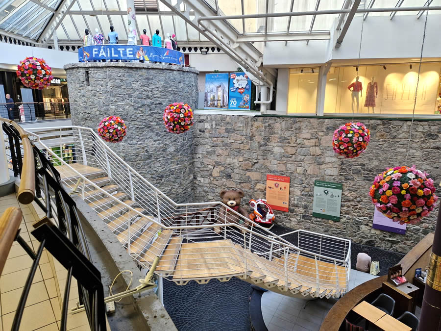 Shopping mall with flower ball decorations and stone walls.