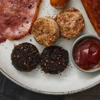 Breakfast plate with meats and sauce.