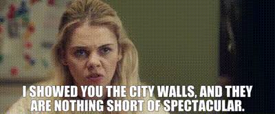 Woman speaking with text overlay about city walls.