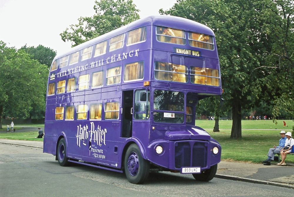 Purple double-decker bus labeled 'Knight Bus' in a park setting.